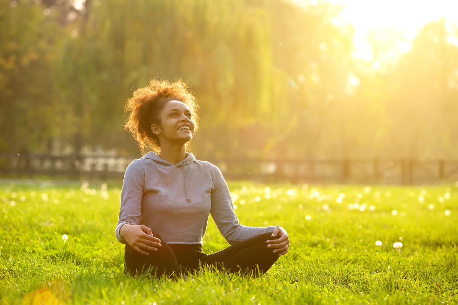 Confident young woman sitting outdoors in yoga position